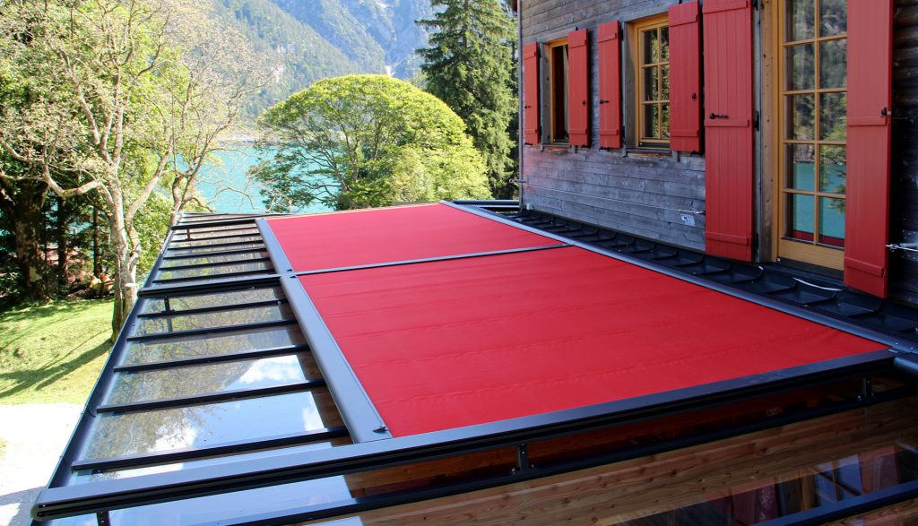 Rote Glasdachmarkise auf einer Terrassenüberdachung zur Reduzierung von Sonneneinstrahlung und Hitze.